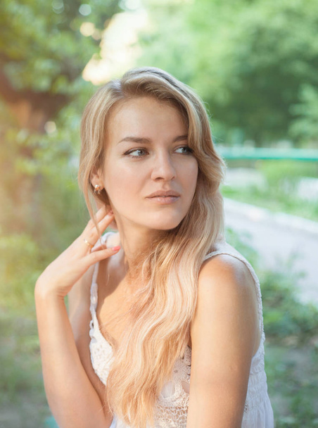 Porträt einer schönen jungen Frau mit langen Haaren über die Natur im Sommer. - Foto, Bild