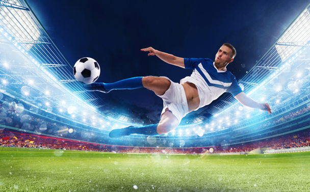 Atacador de futebol atinge a bola com um chute acrobático em um estádio
 - Foto, Imagem