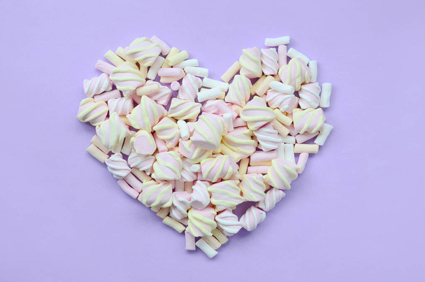 Colorful marshmallow laid out on violet and pink paper background. pastel creative textured heart. minimal. - Photo, Image