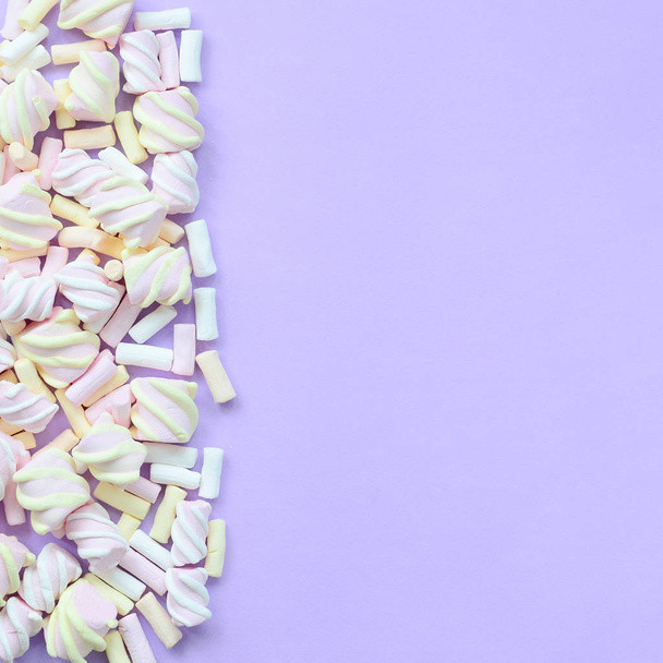 Marshmallow colorato disposto su sfondo di carta viola. texture creativa pastello. minimale
. - Foto, immagini