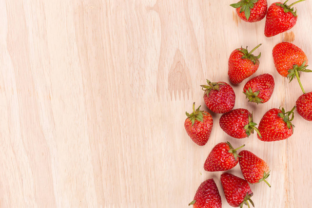 Red strawberries on wooden background. - 写真・画像
