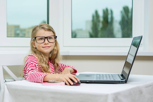 Little businesswoman. Child girl in adult glasses sits at table with computer. - Фото, зображення