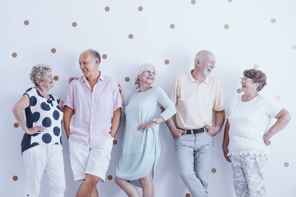 Entusiastas personas mayores sonrientes en ropa de moda posando en el estudio
 - Foto, imagen