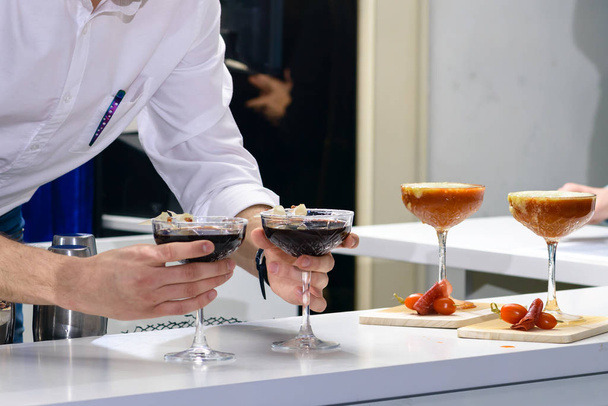 Unknown barman putting martini glasses on bar counter - Photo, image