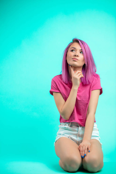bright young beautiful girl with pink colored hair sitting on the floor - Fotoğraf, Görsel