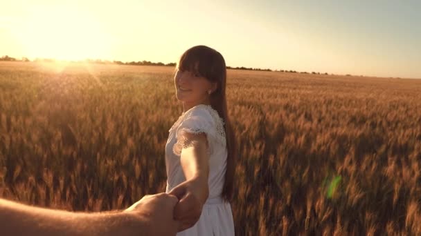 nuori onnellinen pari juoksentelee keltaisen vehnän pellolla auringonlaskun aikaan, onnellinen tyttö nauraa ja hymyilee, hidastettuna
 - Materiaali, video
