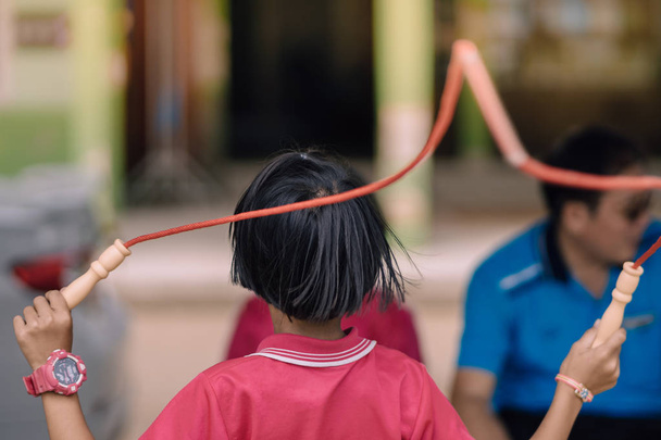 Gli studenti delle scuole elementari godono di un allenamento di salto con la corda per una buona salute prima di pranzo a scuola
. - Foto, immagini