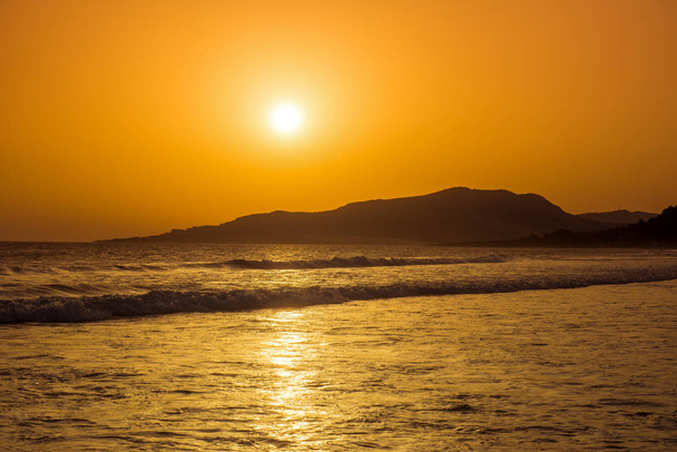 Ongelooflijk mooie zonsondergang op het strand in Spanje. Zon, lucht, zee, golven en zand. Een vakantie aan zee. - Foto, afbeelding