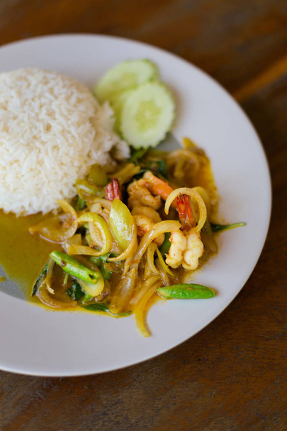 Świeżo przygotowany Azjatki ostry bazylia tajski krewetkami podawane z ryżem jaśminowym w lokalnej restauracji na wyspie Koh Mook. Tradycyjne dania kuchni tajskiej, wykonane ze świeżych składników. - Zdjęcie, obraz