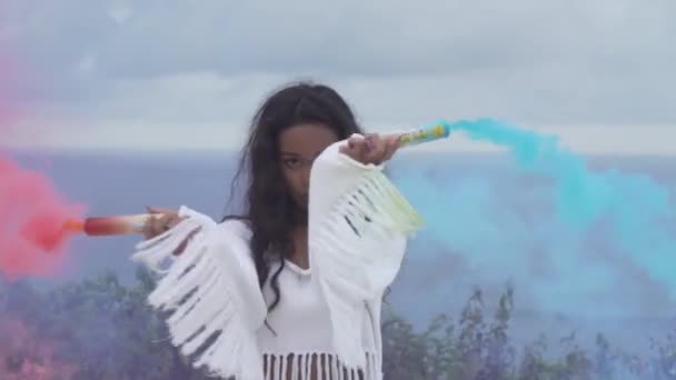 Színes füst játszik a hegyvidéki területen óceán és felhős ég háttér - videó, lassítva a gyönyörű lány portréja - Felvétel, videó