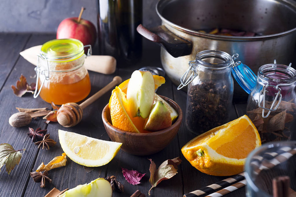 Christmas mulled wine and ingredients. Top view with copyspace , winter warming drink. Bottle of wine, honey, orange, cinnamon sticks, anise, nutmeg, cloves and glass from above. - Foto, Imagem