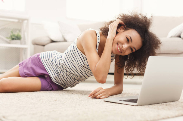 Yerde yatarken dizüstü bilgisayar ile mutlu kız - Fotoğraf, Görsel
