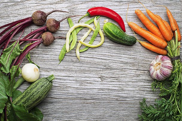 Assortment of fresh vegetables and ingredients on wooden rustic background - Фото, зображення