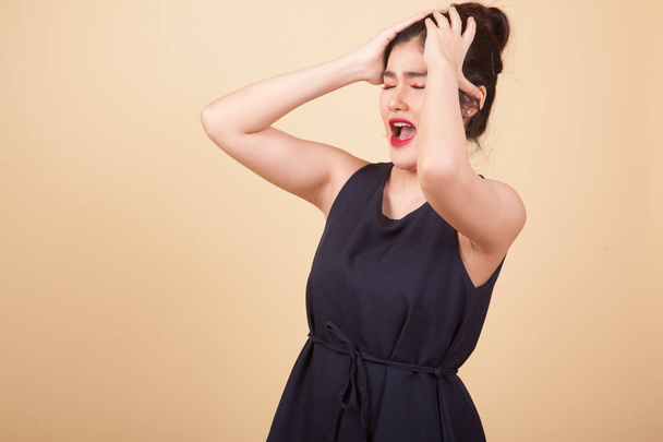 Stressed young Asian businesswoman scream out  on beige background - Zdjęcie, obraz