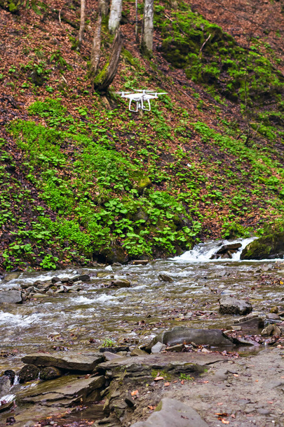 Drone s profesionální fotoaparát pořizuje obrázky hor poblíž jezera, řeky. UAV drone Vrtulník létání s digitálním fotoaparátem. Hexacopter dron s digitální kamerou s vysokým rozlišením na obloze - Fotografie, Obrázek