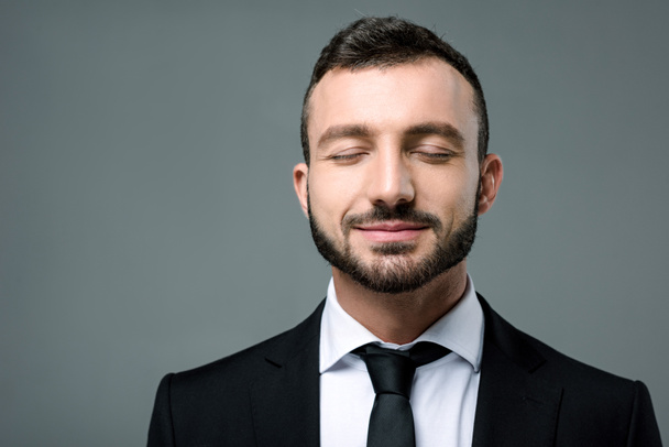 handsome smiling businessman with closed eyes isolated on grey - Φωτογραφία, εικόνα