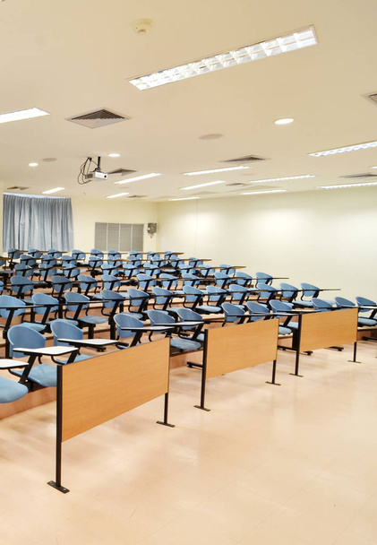 Iso luokkahuone, jossa on paljon sinisiä tuoleja
 - Valokuva, kuva