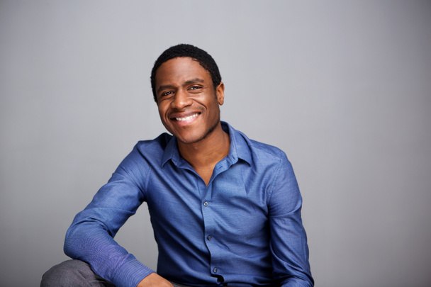 Retrato de belo jovem empresário afro-americano sorrindo contra a parede cinza
 - Foto, Imagem