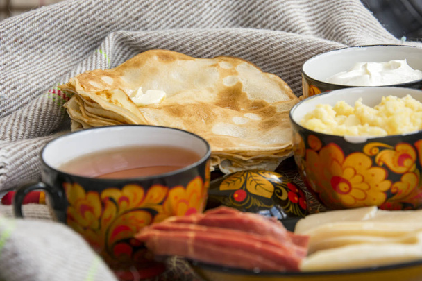 Frühstück im Bett für Ihre Liebsten, Pfannkuchen mit saurer Sahne, Käse und Fleisch, Maisbrei und eine Tasse frisch gebrühten Tee. Guten Morgen! - Foto, Bild