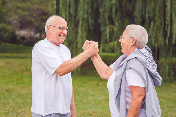 υγιείς ηλικιωμένοι χαμογελώντας ζευγάρι ανάπαυση μετά ασκήσεις sport - μαζί μας καλύτερη προπόνηση - Φωτογραφία, εικόνα