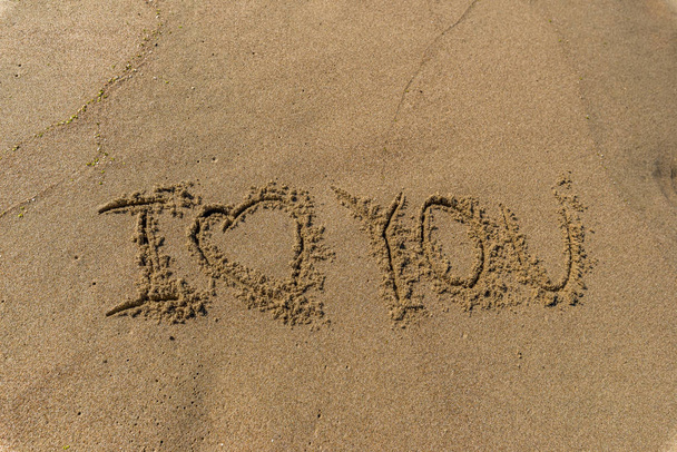 Les mots et le symbole "je t'aime" Écrit dans le sable sur une plage
 - Photo, image