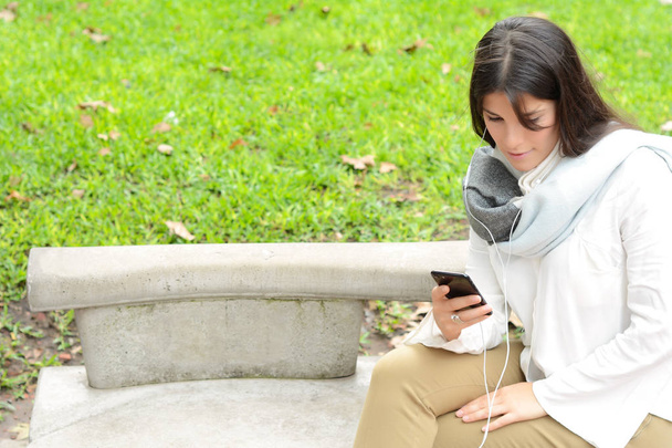 beautiful young woman sending message with smartphone on the street. - Foto, Imagen