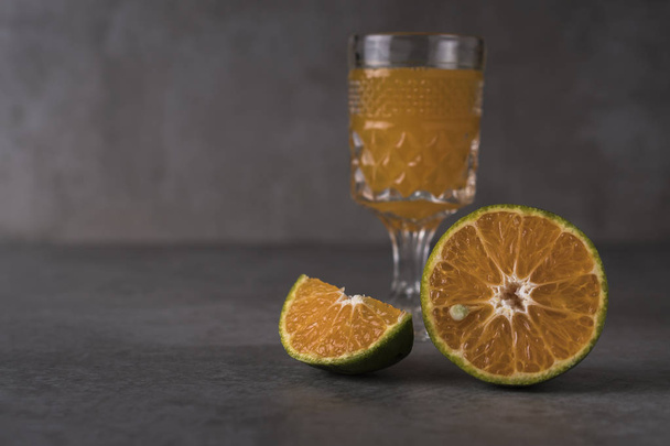 Fresh orange fruits and juice on stone table with copy space - Foto, imagen