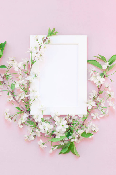 Creative flat lay conceito vista superior de mock quadro em branco e flores de cerejeira em fundo rosa milenar com espaço de cópia em estilo mínimo, modelo para letras, texto ou seu projeto
 - Foto, Imagem