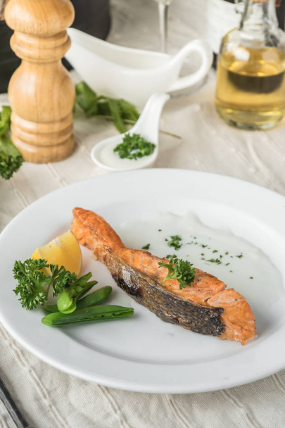 Food composition of grilled salmon steak and vegetables on plate. - Φωτογραφία, εικόνα