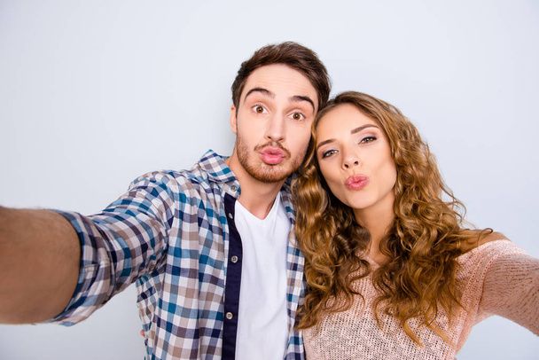 Self portrait of funny comic couple shooting selfie on front camera sending kiss with pout lips having online meeting isolated on grey background. Photography concept - Fotoğraf, Görsel