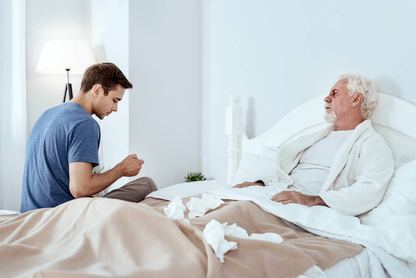 Charming man nursing senior man - Foto, immagini