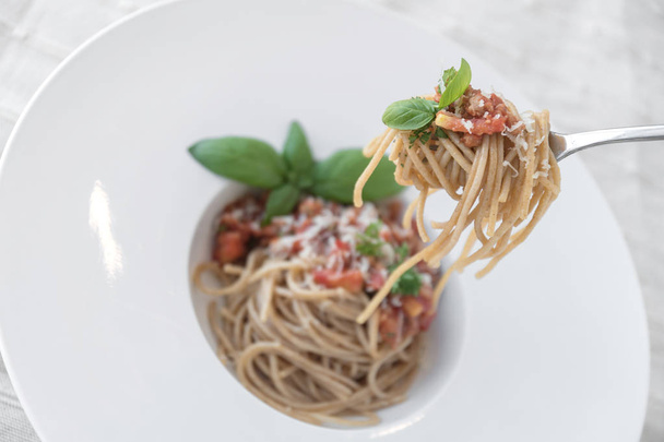 Top view of plate of spaghetti topped with delicious bolognaise sauce and basil - Fotografie, Obrázek
