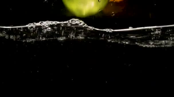 One Green Apple and Two Oranges  Fall Into Water. Slow motion Video - Filmati, video