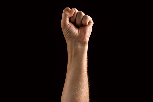 Male fist raised up, isolated on a dark background. Isolate - Фото, зображення