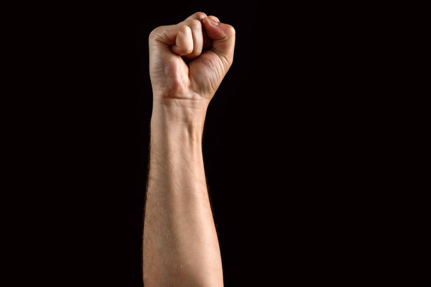 Чоловічий кулак піднятий, ізольований на темному тлі. ізольовані
 - Фото, зображення