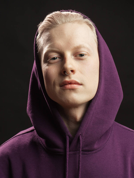 Sports fashion concept. Albino guy posing in sporty clothing isolated over black background. - Photo, Image