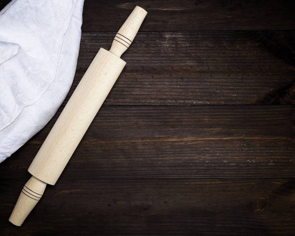 dřevěný váleček a bílou textilní ručník na hnědý dřevěný stůl, kopie prostor - Fotografie, Obrázek