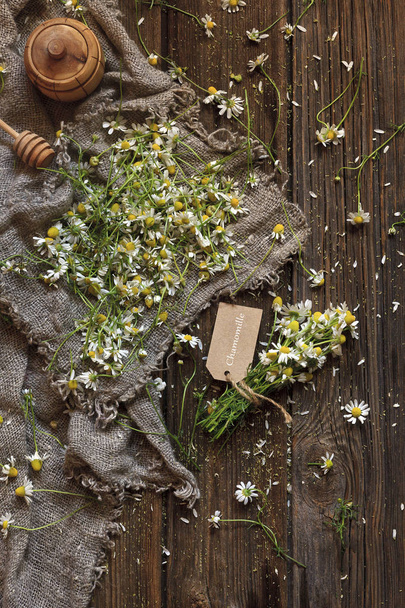 Close-up photo of chamomile on canvas. Top view on vintage wood background - Фото, зображення