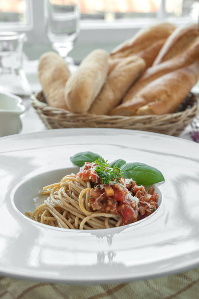 Prato de espaguete coberto com delicioso molho de bolonhesa e manjericão
 - Foto, Imagem