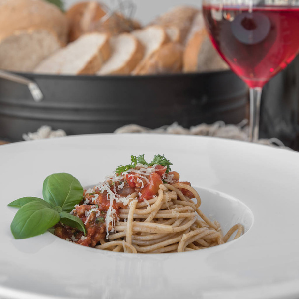 Closeup lof plate of spaghetti topped with delicious bolognaise sauce and basil - Photo, Image