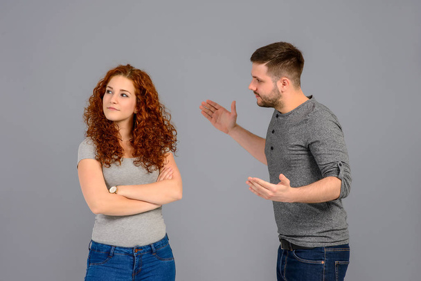 A beautiful young couple standing and arguing in the studio - Foto, afbeelding