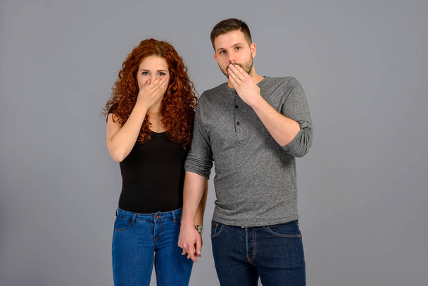 A beautiful young couple standing and feeling scared in a studio - Foto, imagen