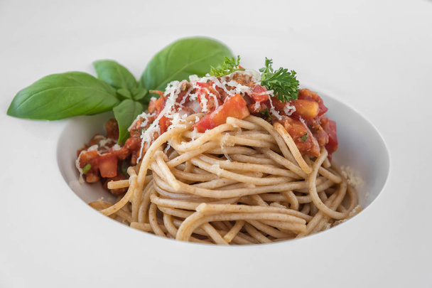 Delicious spaghetti topped with delicious bolognaise sauce and basil - Фото, изображение
