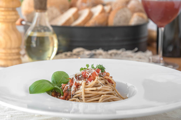 Closeup of spaghetti topped with delicious bolognaise sauce and basil - Foto, afbeelding