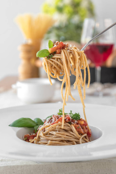 Closeup of fork with rolled spaghetti topped with delicious bolognaise sauce and basil - Fotoğraf, Görsel