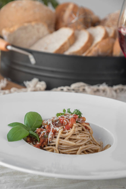 Closeup of spaghetti topped with delicious bolognaise sauce and basil - Photo, image