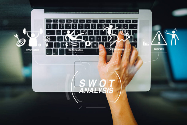 SWOT Analysis віртуальна діаграма з сильними, слабкими сторонами, загрозами та можливостями company.businessman, що друкує клавіатуру з ноутбуком на дерев'яному столі в сучасному офісі
  - Фото, зображення