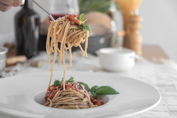 Fork with spaghetti topped with delicious bolognaise sauce and basil - Фото, зображення