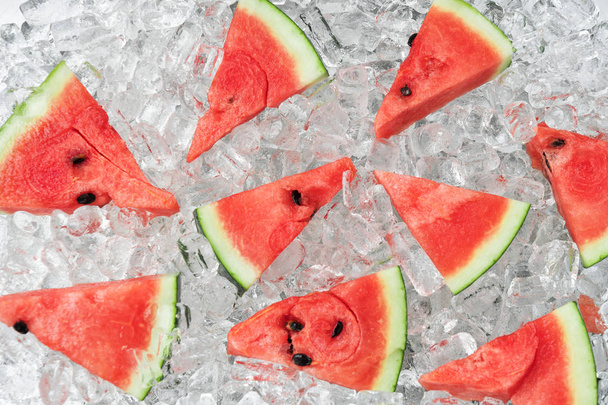 Watermelon slices placed on ice cubes - Фото, зображення