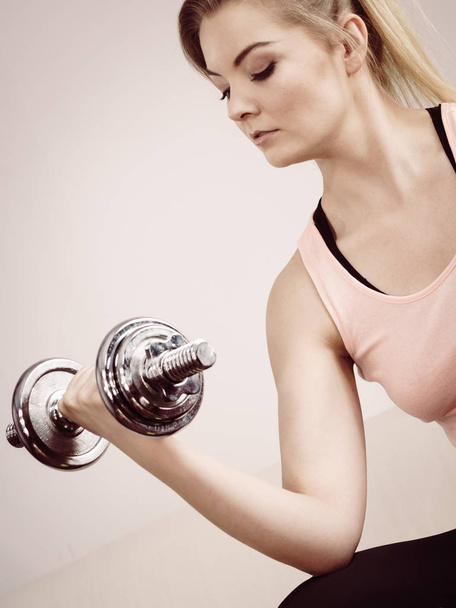 Young woman working out at home with heavy dumbbells. Training at home, being fit and healthy. - Valokuva, kuva